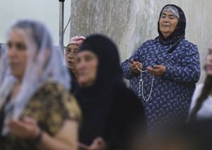 Un gruppo di donne cristiane cacciate dall'area di Mosul pregano in una chiesa nella zona di Ninive. Questa foto, dell'agenzia Reuters, è stata scattata durante le funzioni serali di sabato 19 luglio. 