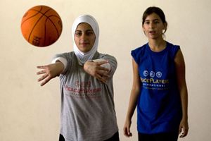 Una ragazzina palestinese e una israeliana giocano insieme a basket.