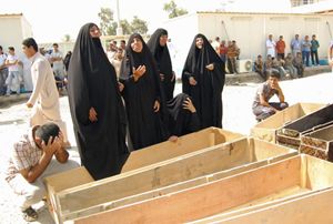 Donne di Baghdad aspettano davanti alla morgue, con le bare vuote, la restituzione dei corpi dei loro uomini uccisi negli attentati dei giorni scorsi. 