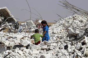 Due bambini siriani tra le macerie di una casa ad Aleppo (Reuters).