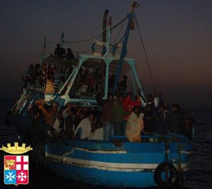 Un barcone di migranti in attesa di soccorsi al largo di Lampedusa