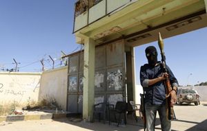 Un miliziano all'ingresso di una raffineria in Libia (Reuters).