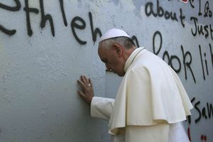 Il Papa in meditazione al muro che divide Israele dai territori palestinesi (Reuters).