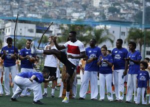 Il calciatore della Nazionale inglese Danny Welback si cimenta nella capoeira durante una visita alla favela Rocinha a Rio (Reuters).