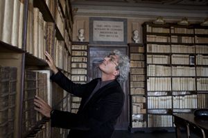 Il regista Mario Martone nella biblioteca nella casa di Leopardi a Recanati. In alto: Elio Germano.