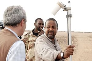 Yusuf con il giornalista dell'Agi Angelo Ferrari in Somalia, nel 2005. L'ambasciatore somalo sta usando un magnetometro a protoni, strumento usato per individuare fusti metallici nel sottosuolo.