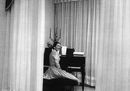 02_Maria Callas nella sua casa milanese seduta al pianoforte, con il candelabro donatole dal teatro alla Scala, 1955