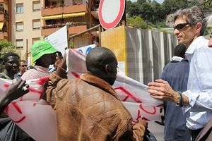 Maurizio Marmo, direttore della Caritas diocesana, parla con alcuni migranti.