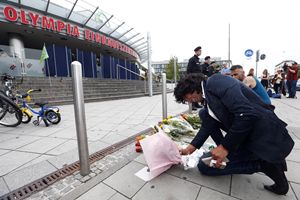 Un uomo depone dei fiori davanti al luogo della strage di Monaco di Bavuera (foto Reuters)