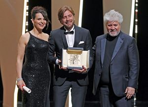 Il momento della premiazione del regista Ruben Ostlund , Palma d'Oro col film "The Square", insieme a Juliette Binoche e al presidente della giuria del Festival Pedro Almodovar.