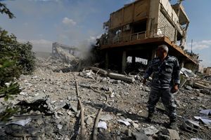 Un pompiere siriano vicino al Centro di ricerca scientifica di Damasco, in Siria, distrutto dopo il bombardamento americano (Reuters)