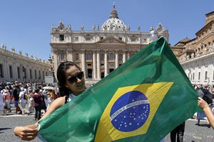 Una fedele in piazza San Pietro prima dell'Angelus con la bandiera del Brasile. Al popolo brasiliano, la cui squadra di calcio è stata eliminata dai mondiali, il Papa ha inviato un affettuoso saluto