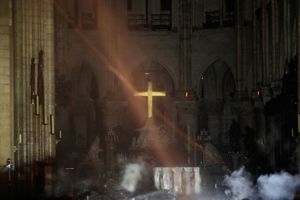 Quel che resta attorno all'altare maggiore dopo l'incendio con la Croce rimasta intatta al suo posto (Reuters)