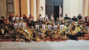 Nella foto: il gruppo di persone che da oltre una settimana dorme col parroco di Lampedusa, don Carmelo La Magra, sul sagrato della Chiesa. La Magra ha detto che continuerà a farlo finché i 42 migranti non saranno sbarcati.