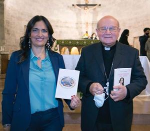 La giornalista Safira Leccese mostra il logo del premio; al suo fianco, il vescovo di Assisi monsignor Domenico Sorrentino.