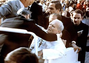 Papa Giovanni Paolo II, sorretto dai collaboratori, qualche istante dopo l'attentato, il 13 maggio 1981, in piazza San Pietro. Foto Ansa.