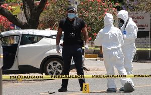 Poliziotti e medici legali lavorano sul luogo dov'è stata uccisa Ivonne Gallegos, candidata sindaco a Ocotlan de Morelos, nello Stato di Oaxaca, in Messico, il 20 marzo 2021. Foto Ansa. 
