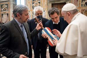 Papa Francesco in Vaticano mentre benedice il "Violino del Mare" lo scorso il 4 febbraio. Lo strumento è stato ricavato dai barconi di Lampedusa, portati in carcere nel Natale 2021, ed è stato suonato per la prima volta davanti a lui in quella occasione.