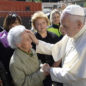 Papa Francesco, oggi 85 anni, saluta una signora avanti con gli anni. Foto Ansa. Sopra foto Osservatore Romano / Vatican Media
