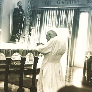 Il beato Giacomo Alberione (1884-1971) raccolto in preghiera vicino a una statua raffigurante san Paolo. 