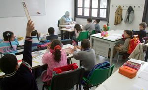Sopra: alunni stranieri in una classe italiana. Foto Ansa. In alto e in copertina: una mamma immigrata accompagna suo figlio a scuola. Foto Ansa. 