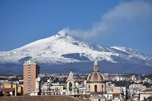 Catania nei giorni scorsi. Sullo sfondo: il vulcano Etna imbiancato dalla neve. Foto: agenzia Ansa. Sopra e in copertina: momenti della processione di Sant'Agata. Foto: agenzia Ansa . 
