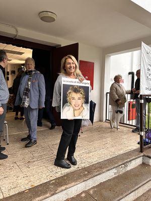 Anna Melato stringe tra le mani la foto della sorella Mariangela davanti all'ingresso del teatro del Trotter