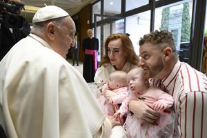 Francesco riceve una famiglia in Vaticano.